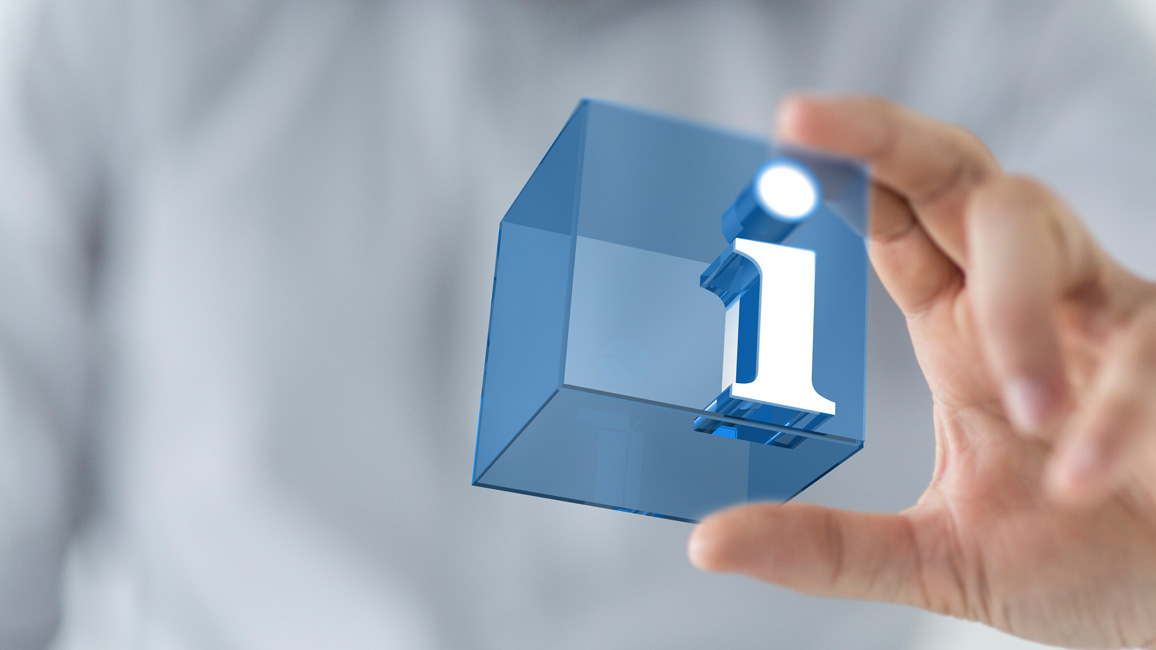 Ein blauer, leicht transparenter Würfel mit dem Buchstaben „i“, gehalten von einer verschwommen zu sehenden Person im Hintergrund.
